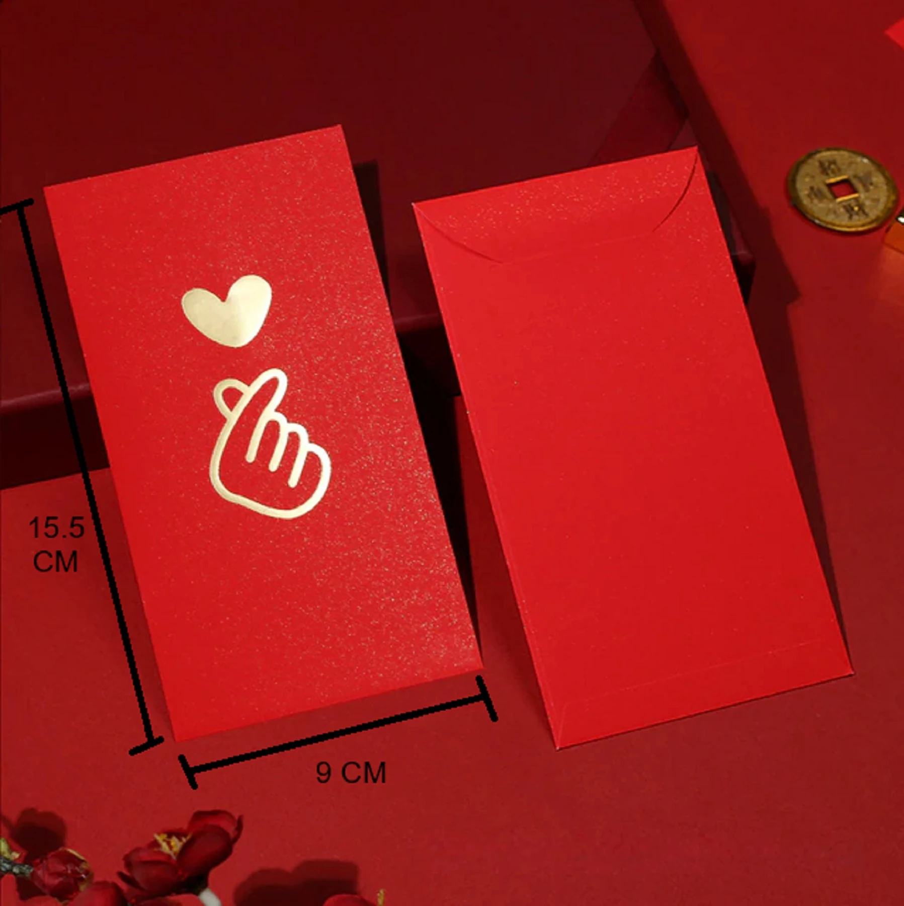 May include: Two red envelopes with gold accents. One envelope has a gold heart and a gold hand making a heart shape. The envelopes measure 9 inches by 15.5 inches.