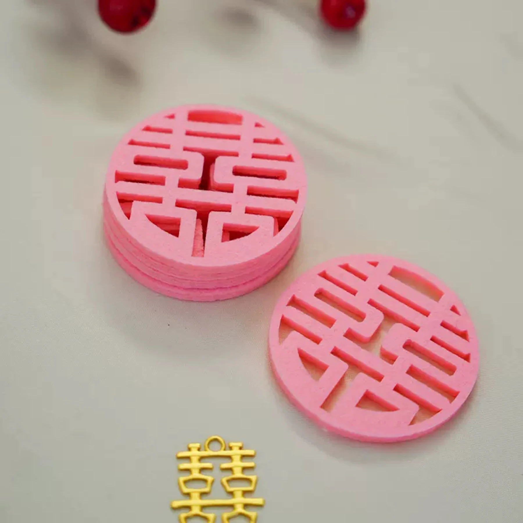 May include: Two pink round paper cutouts with a traditional Chinese double happiness symbol. A gold double happiness charm is also pictured.