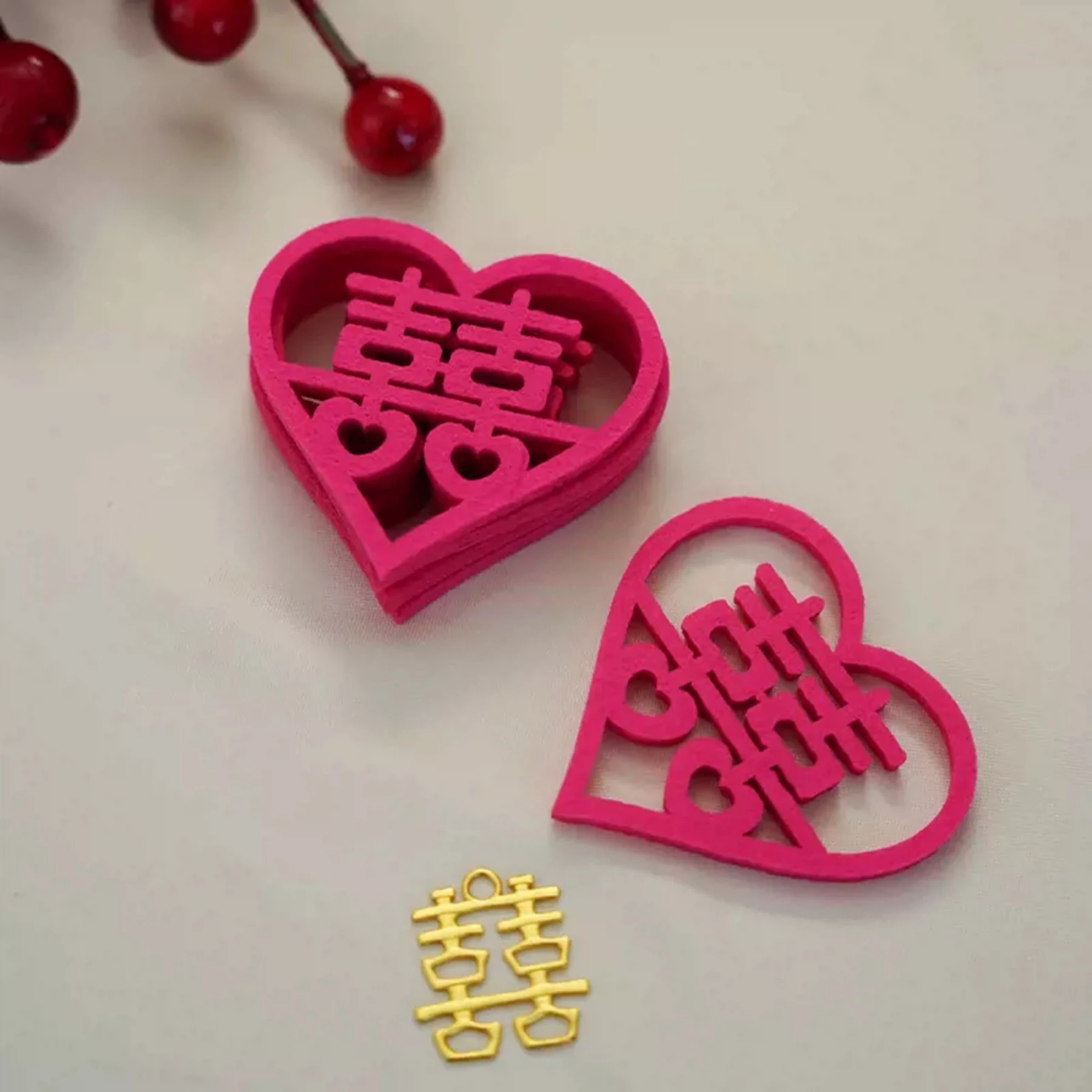 May include: Two pink felt hearts with the Chinese character for double happiness cut out. A gold double happiness charm is also pictured.