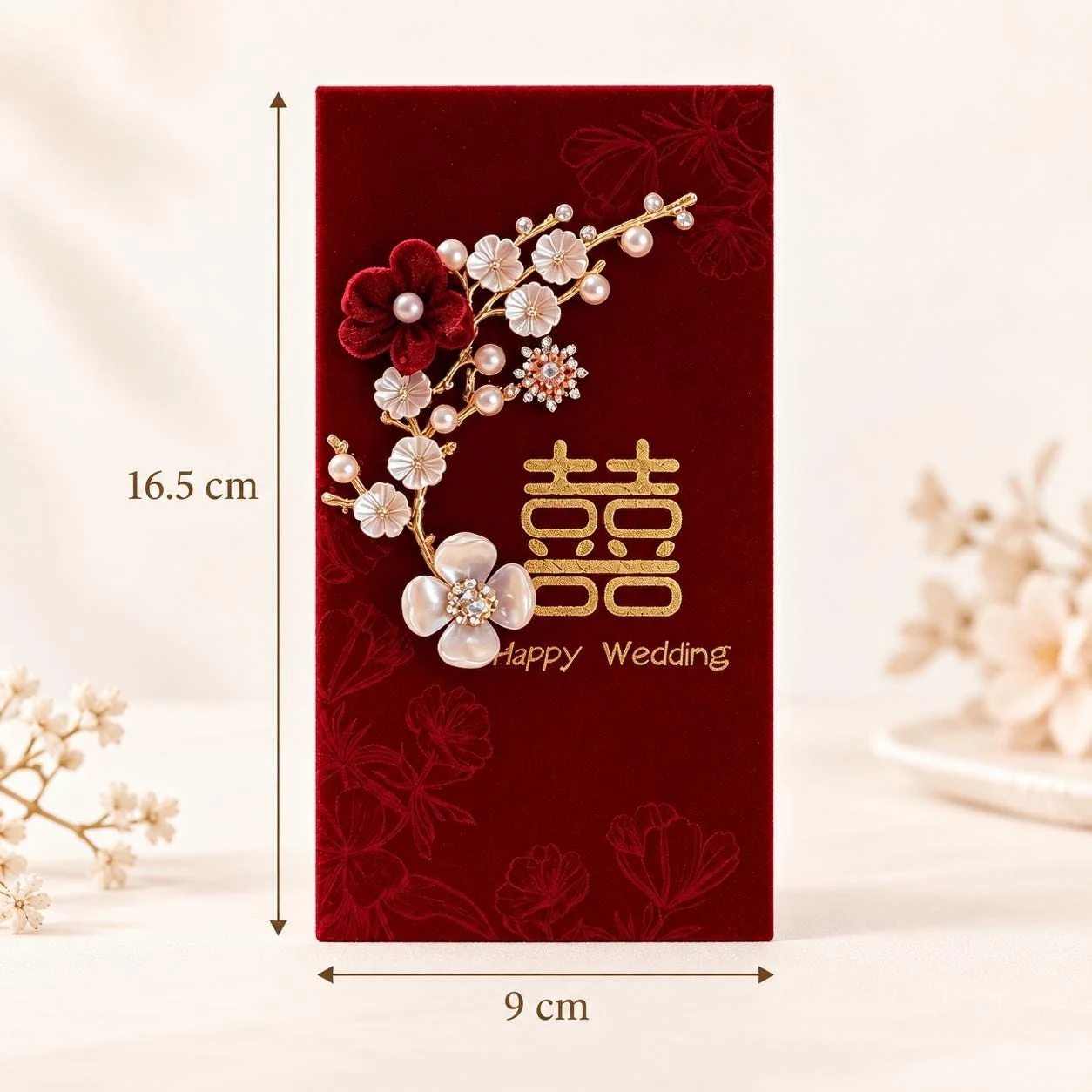 May include: A rectangular red velvet envelope measuring 16.5 cm by 9 cm. It features a gold double happiness symbol, the text "Happy Wedding," and a decorative branch with white and dark red fabric flowers, pearls, and crystals.