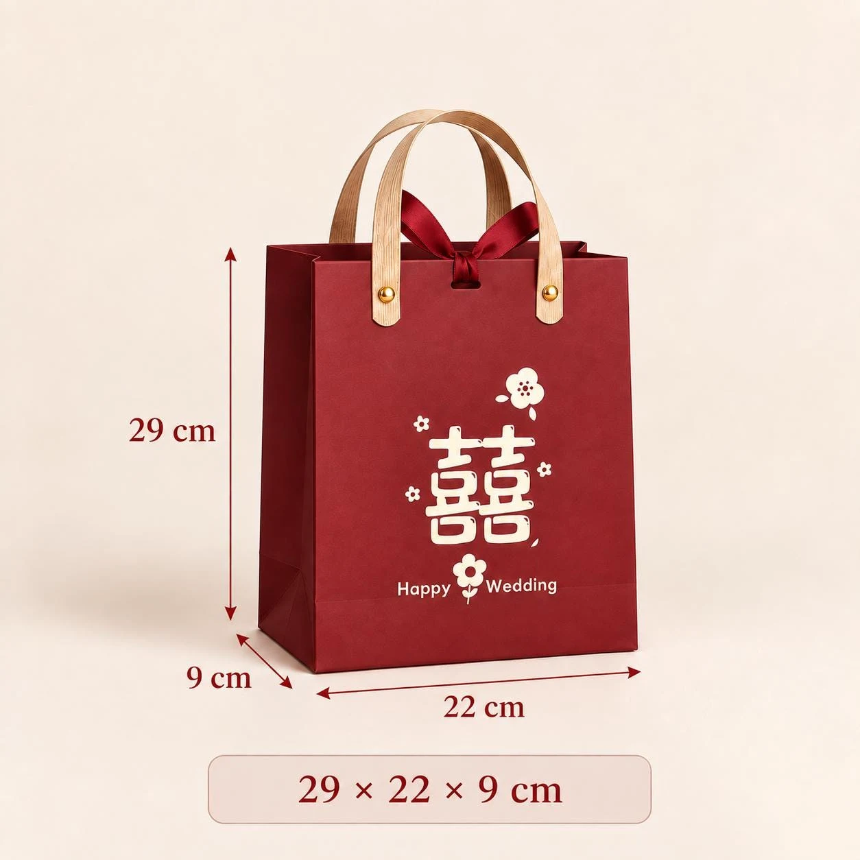 May include: A deep red gift bag with light brown handles and a dark red ribbon bow. The front features a white double happiness symbol, small flower icons, and the text Happy Wedding. Dimensions are 29 cm in height, 22 cm in width, and 9 cm in depth.